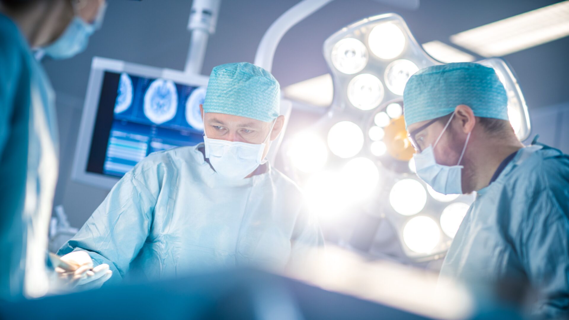 Two surgeons in a hospital operating room with lights